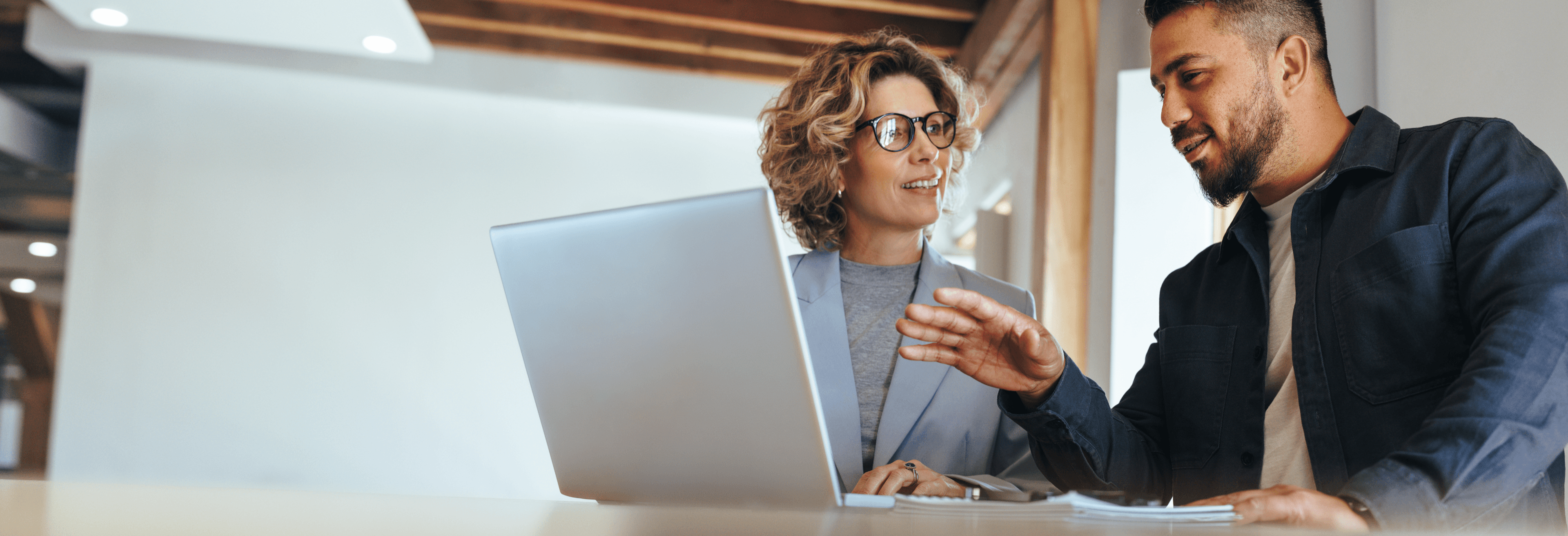 Professionelle Frau mit Laptop und Headset am Arbeitsplatz